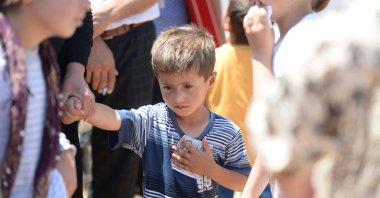 4-years-old child of Hacı Atilla, one of the four victims of the Wednesday's PKK terrorist attack took place in Şırnak, holds the picture of his father during Atilla's funeral, June 18, 2020. (AA)