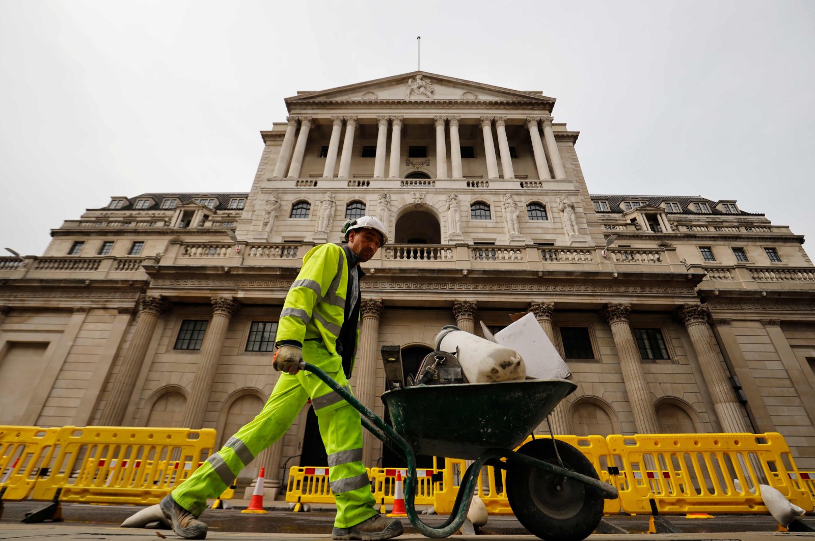 A worker pushes a wheelbarrow of debris outside the Bank of England in London, June 17, 2020. (AFP)