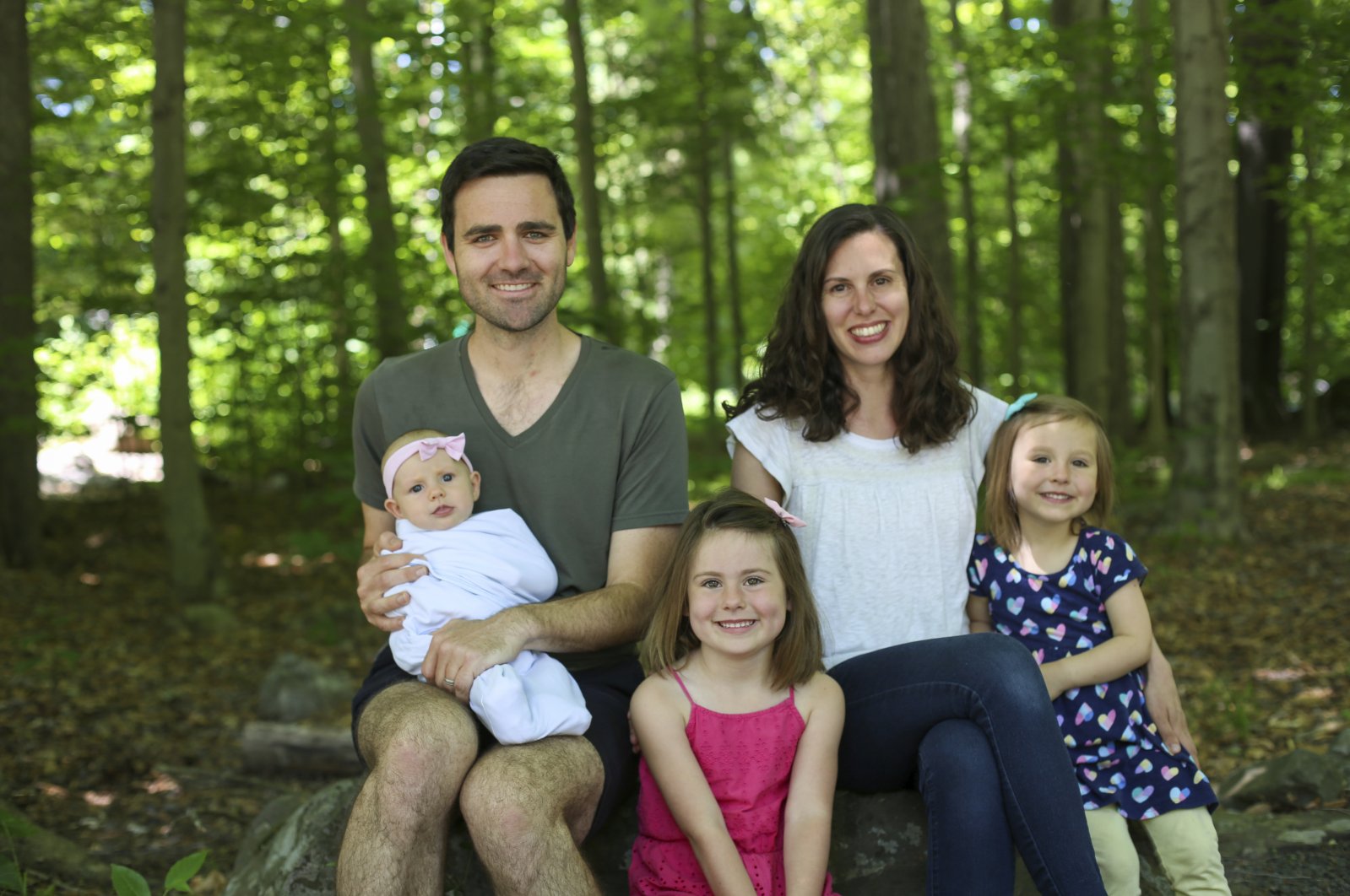 This June 17, 2020 photo shows Tyler Moore, his wife, Emily Moore, and daughters Mabel, 5, center, Matilda, 3, and Margaret, 3 months. (Pamela Henderson via AP).