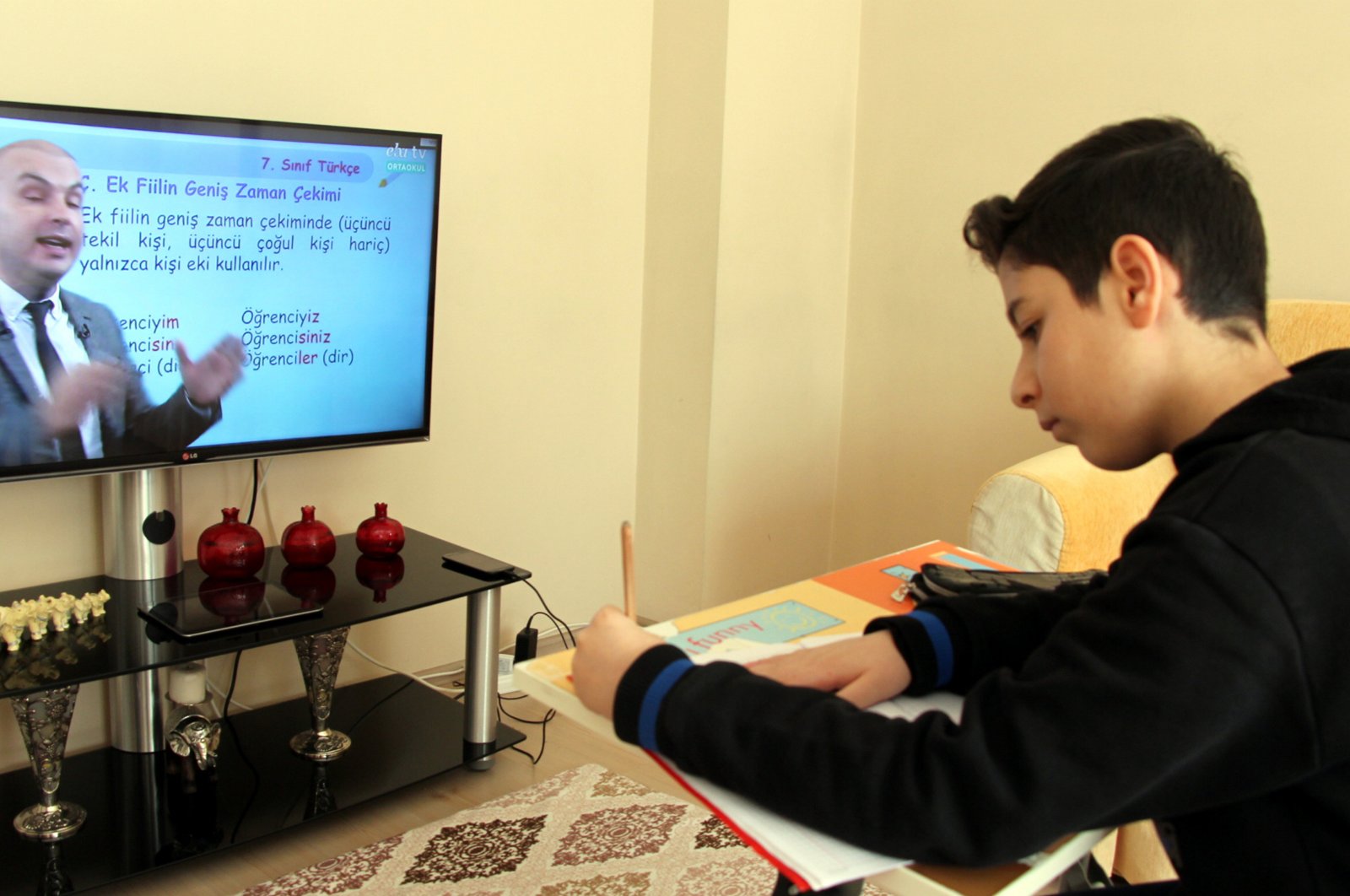 A student takes notes as he watches a remote education program, in Elazığ, Turkey, in this undated photo. (AA Photo)