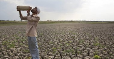 In this May 10, 2016, photo, a Shepard drinks water on the dry bed of Manjara Dam, which supplies water to Latur and nearby villages in Marathwada region, in the Indian state of Maharashtra. Many people are forced to leave their hometown due to changes in their local environment.  (AP Photo)