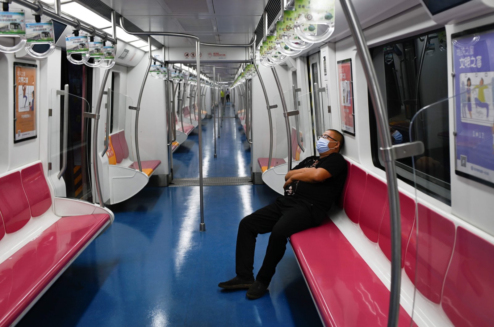 A man wearing a face mask sits on a subway train in Beijing on June 20, 2020 (AFP Photo)
