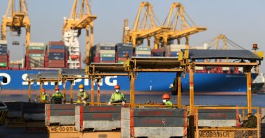 Employees wearing face masks against the coronavirus keep at a safe distance from each other, as they work at the port of Jebel Ali, operated by the Dubai-based giant ports operator DP World, in the southern outskirts of the Gulf emirate of Dubai, on June 18, 2020. (AFP Photo)