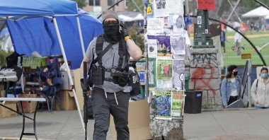 A person carries a rifle as he walks near what has been named the Capitol Hill Occupied Protest (CHOP) zone, Seattle, June 20, 2020