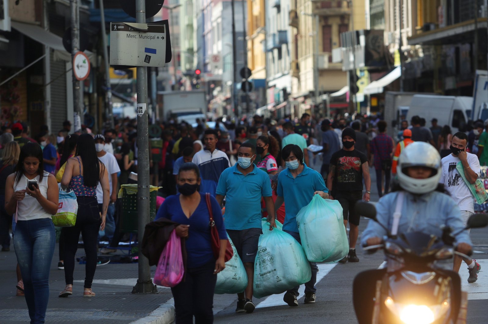 People walk with bags at a popular shopping street, Sao Paulo, Brazil, June 19, 2020. (REUTERS Photo)