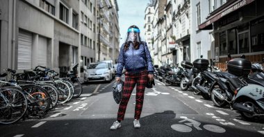 A woman, wearing a protective face shield, poses for a photograph in the streets of Paris, France, May 4, 2020. (AFP Photo)
