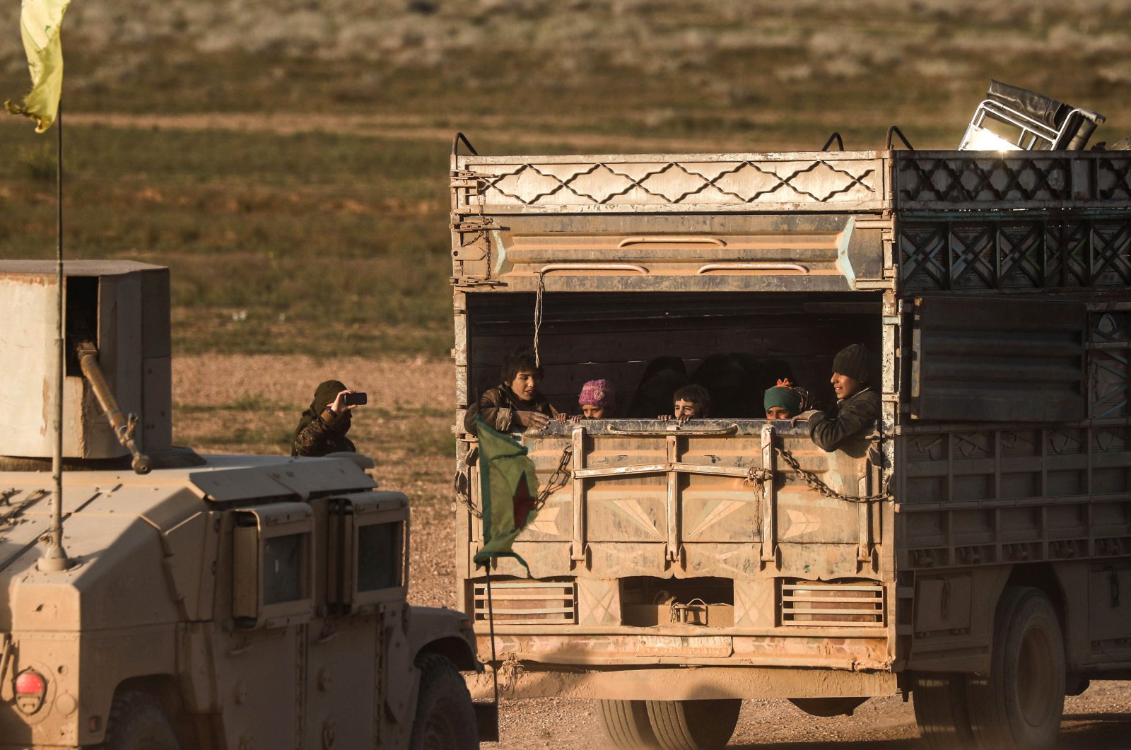 People evacuated from the Daesh terrorist group's embattled holdout of Baghouz sit in the back of a truck on Feb. 25, 2019.