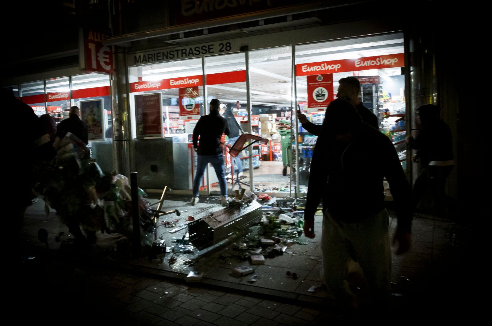 People stand in front of a shop that was plundered during riots in Stuttgart, southern Germany, June 21, 2020. (AFP Photo)