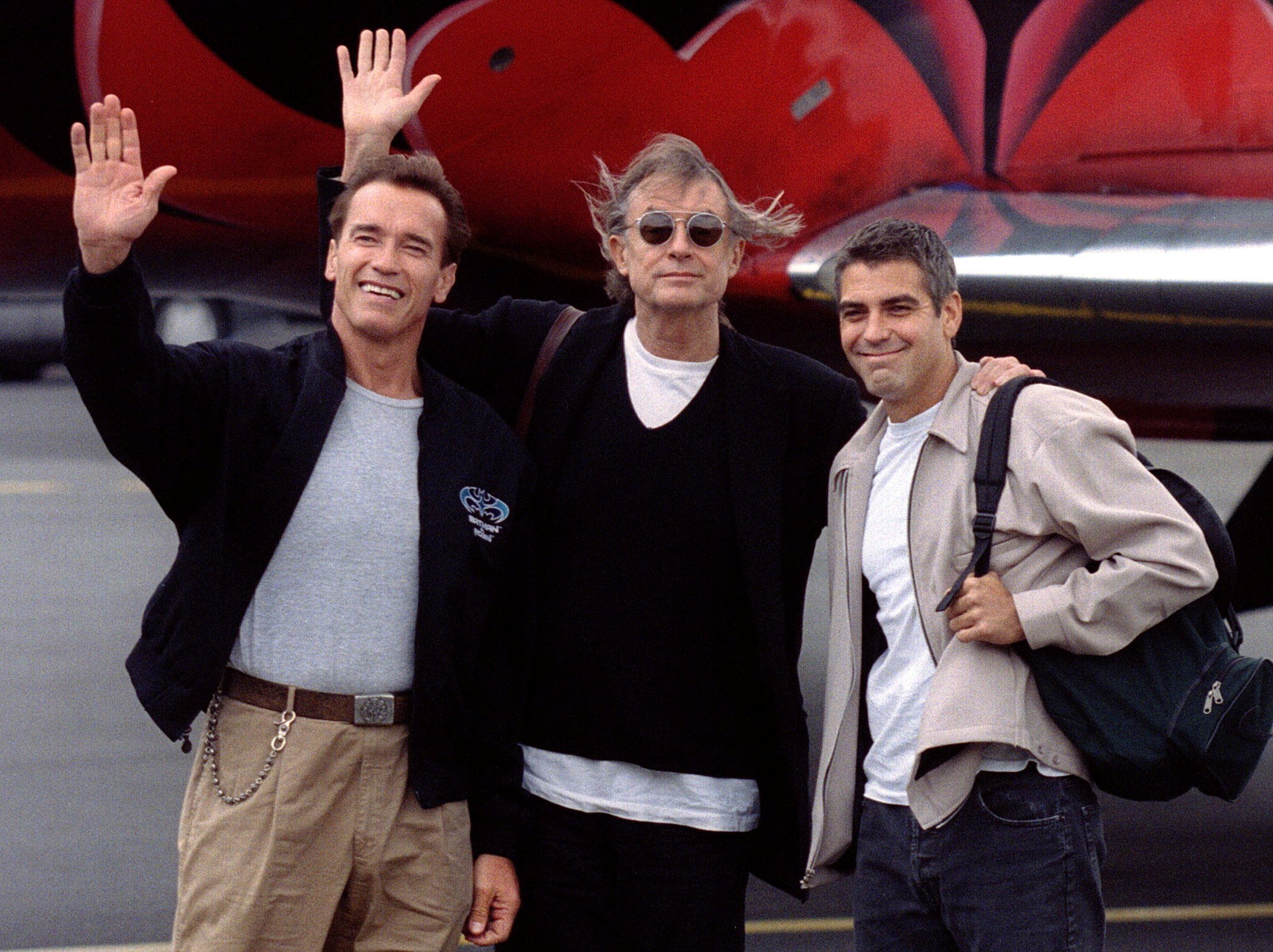 Stars of 'Batman and Robin,' Arnold Schwarzenegger (L) and George Clooney (R), and director Joel Schumacher wave at photographers after landing at Le Bourget airport near Paris, June 24. (Reuters Photo)