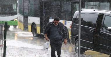 A man runs for cover under heavy rain in Bursa, Turkey, June 23, 2020. (IHA Photo) 
