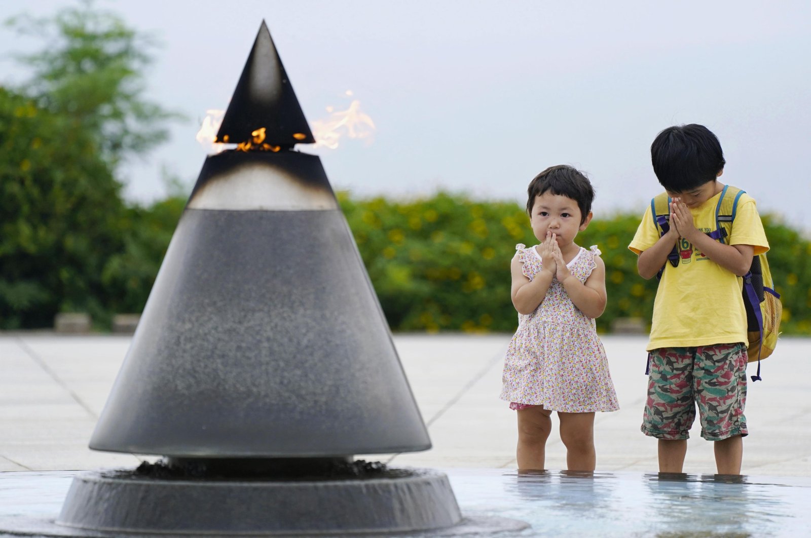 Children pray in front of the "Peace of Fire" at the Peace Memorial Park in Itoman, Okinawa, Japan, June 23, 2020. (AP Photo)