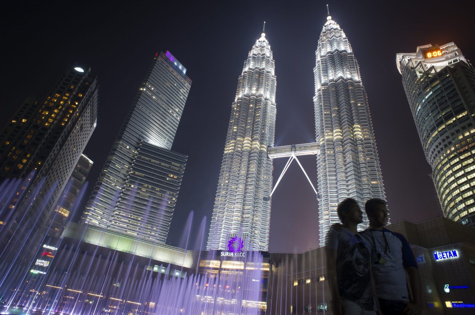 Tourists have their photograph taken in front of the Petronas Twin Towers in Kuala Lumpur, Malaysia, March 10, 2015. (AP Photo)