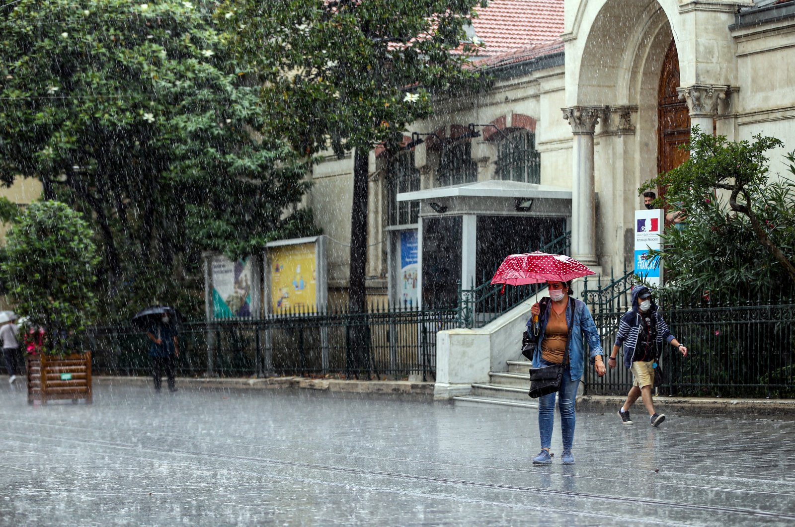 People weather a downpour in Taksim Square, Istanbul, Turkey, June 23, 2020. (AA Photo)
