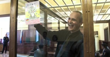 In this file image taken from video, Dennis Christensen shows a picture in a courtroom in Oryol, Russia, May 23, 2019. (AP Photo)