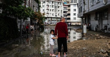 A man and a child stand in a flooded street in the Esenyurt district, Istanbul, Turkey, June 23, 2020. (AFP Photo)