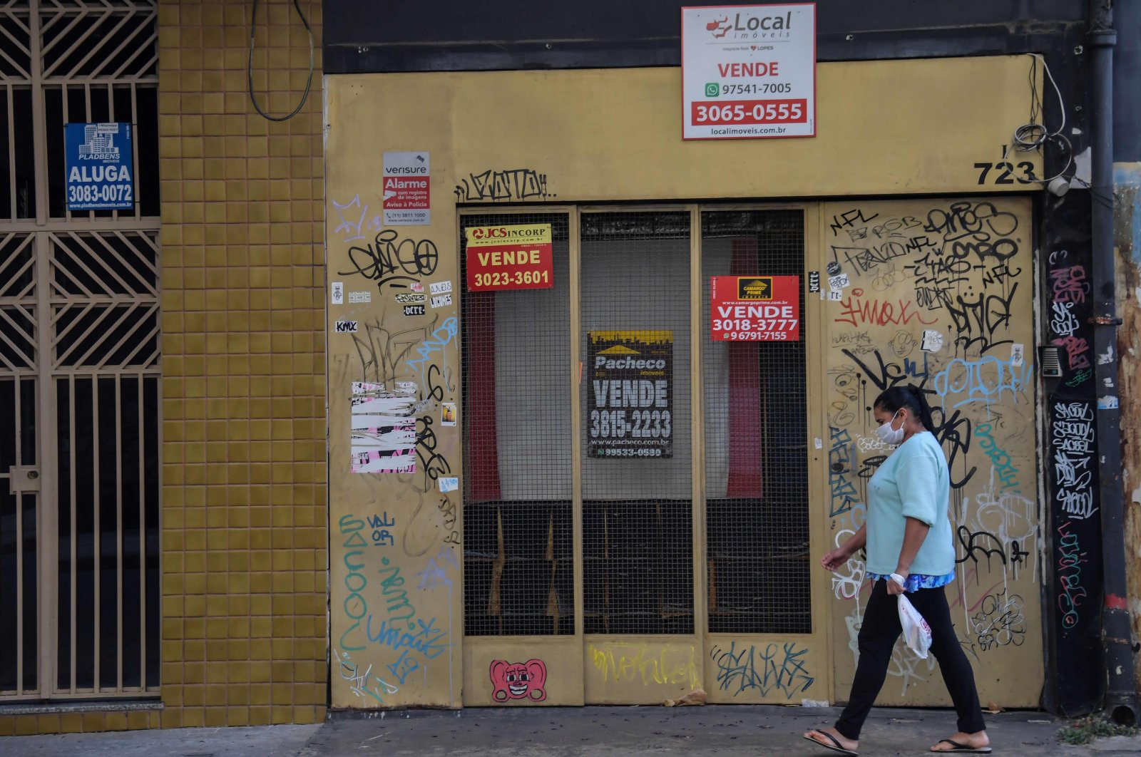 A woman walks past an empty store to sell in a commercial area of Sao Paulo, June 17, 2020. (AFP Photo)