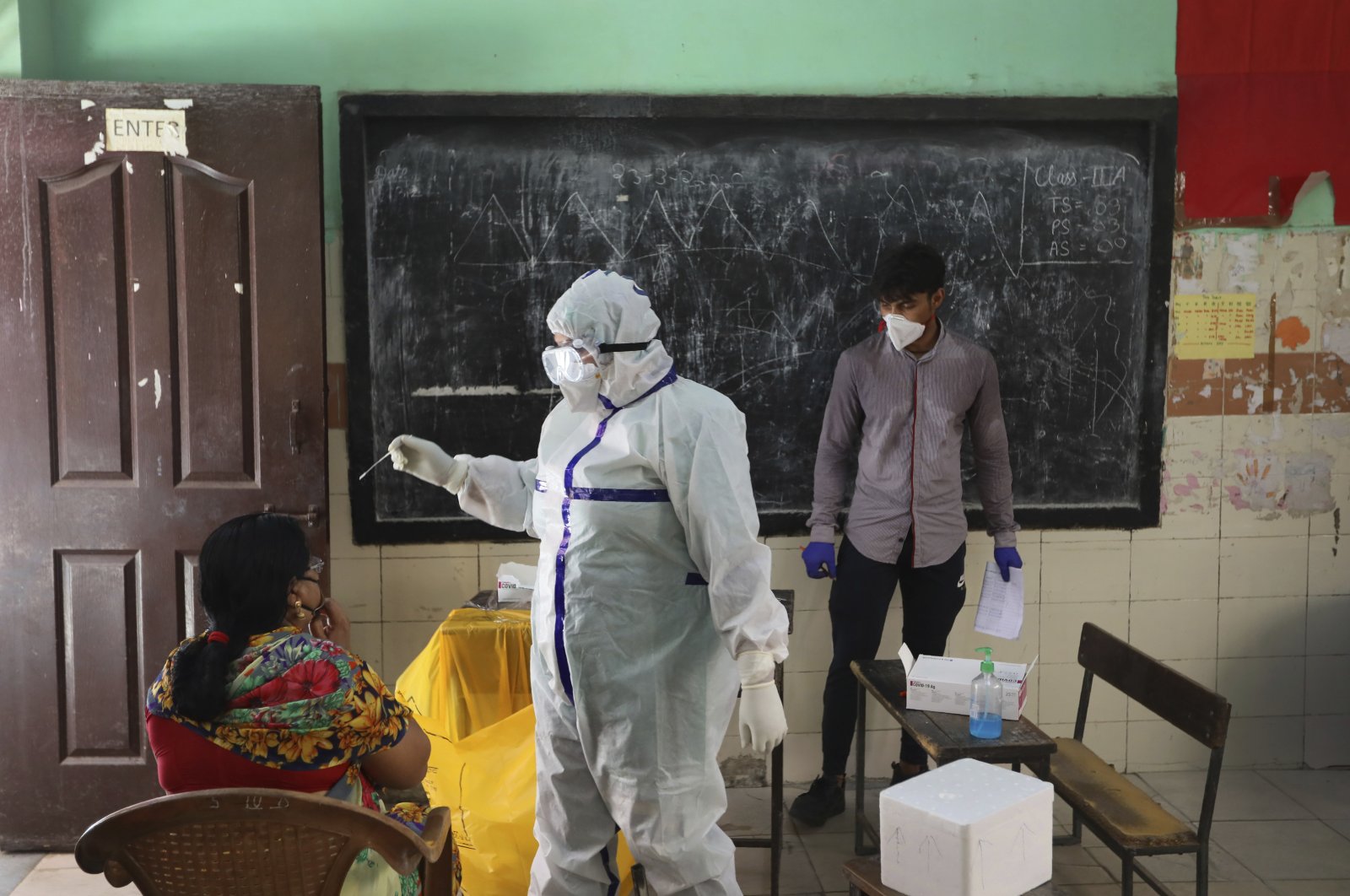 A health worker takes a swab sample of a woman for a COVID-19 test in New Delhi, India, June 24, 2020. (AP Photo)