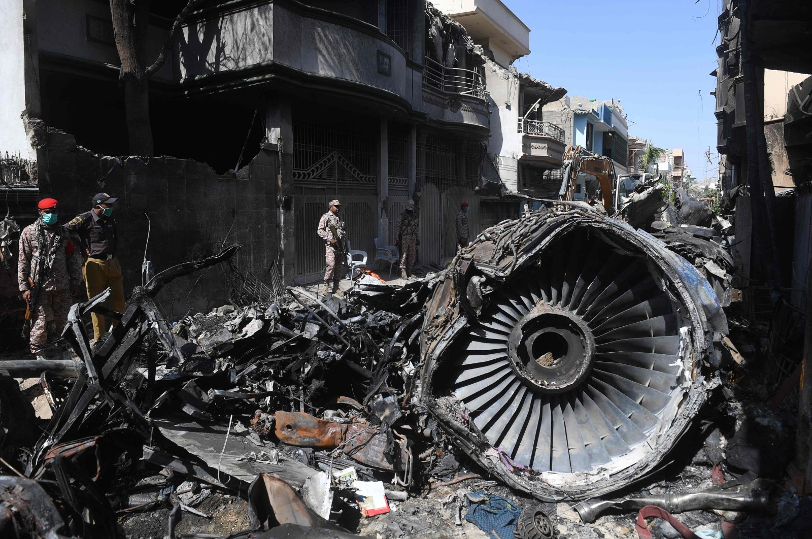 Security personnel stand beside the wreckage of a Pakistan International Airlines aircraft, in Karachi, Pakistan, May 24, 2020. (AFP Photo)