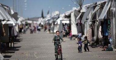 A Syrian refugee child rides his bike at the Öncüpınar Camp for refugees next to the border crossing with Syria in Turkey's Kilis province, March 17, 2016. (AP File Photo)