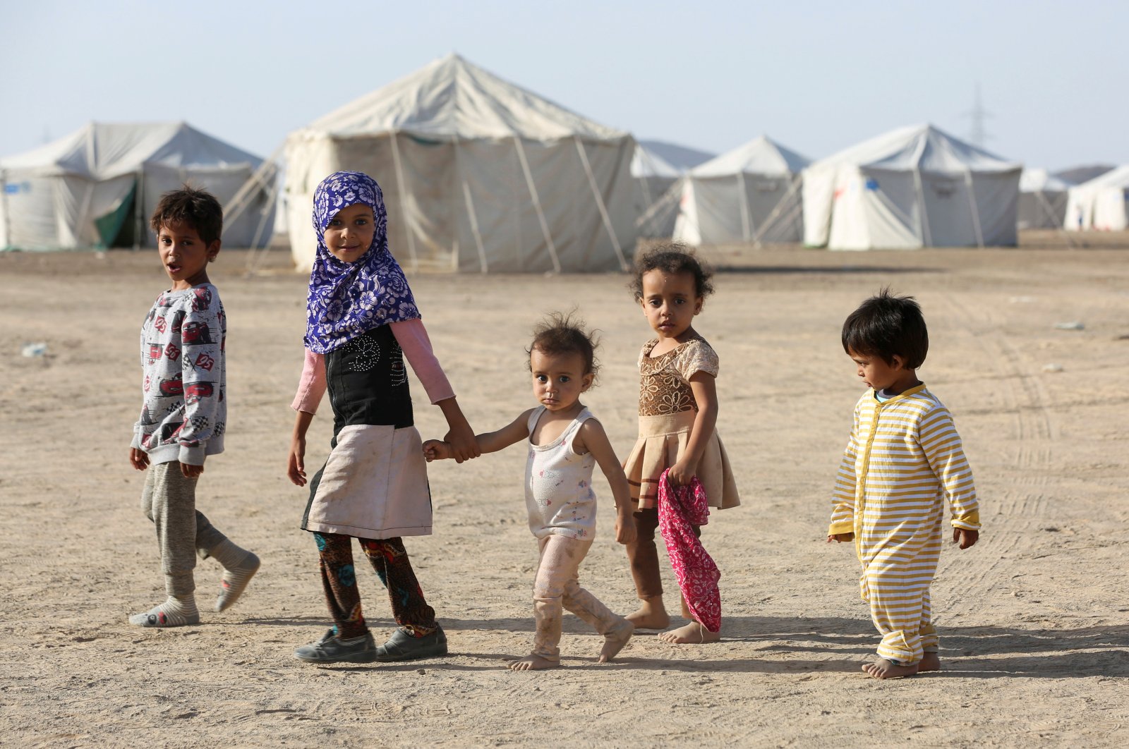 Children walk at a camp for people recently displaced by fighting in Yemen's northern province of al-Jawf between government forces and Houthis, in Marib, Yemen March 8, 2020. (Reuters Photo)