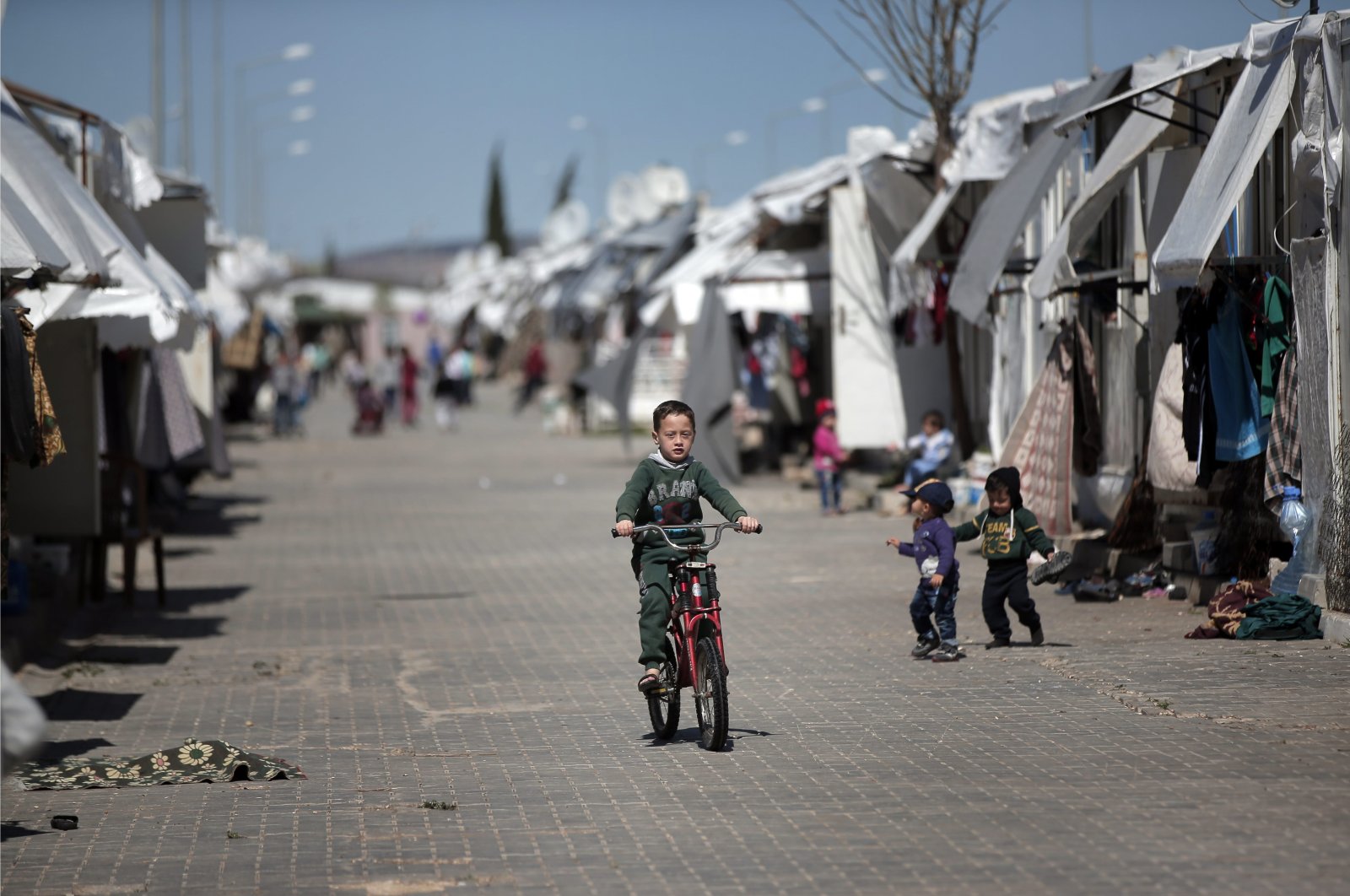 A Syrian refugee child rides his bike at the Öncüpınar Camp for refugees next to the border crossing with Syria in Turkey's Kilis province, March 17, 2016. (AP File Photo)