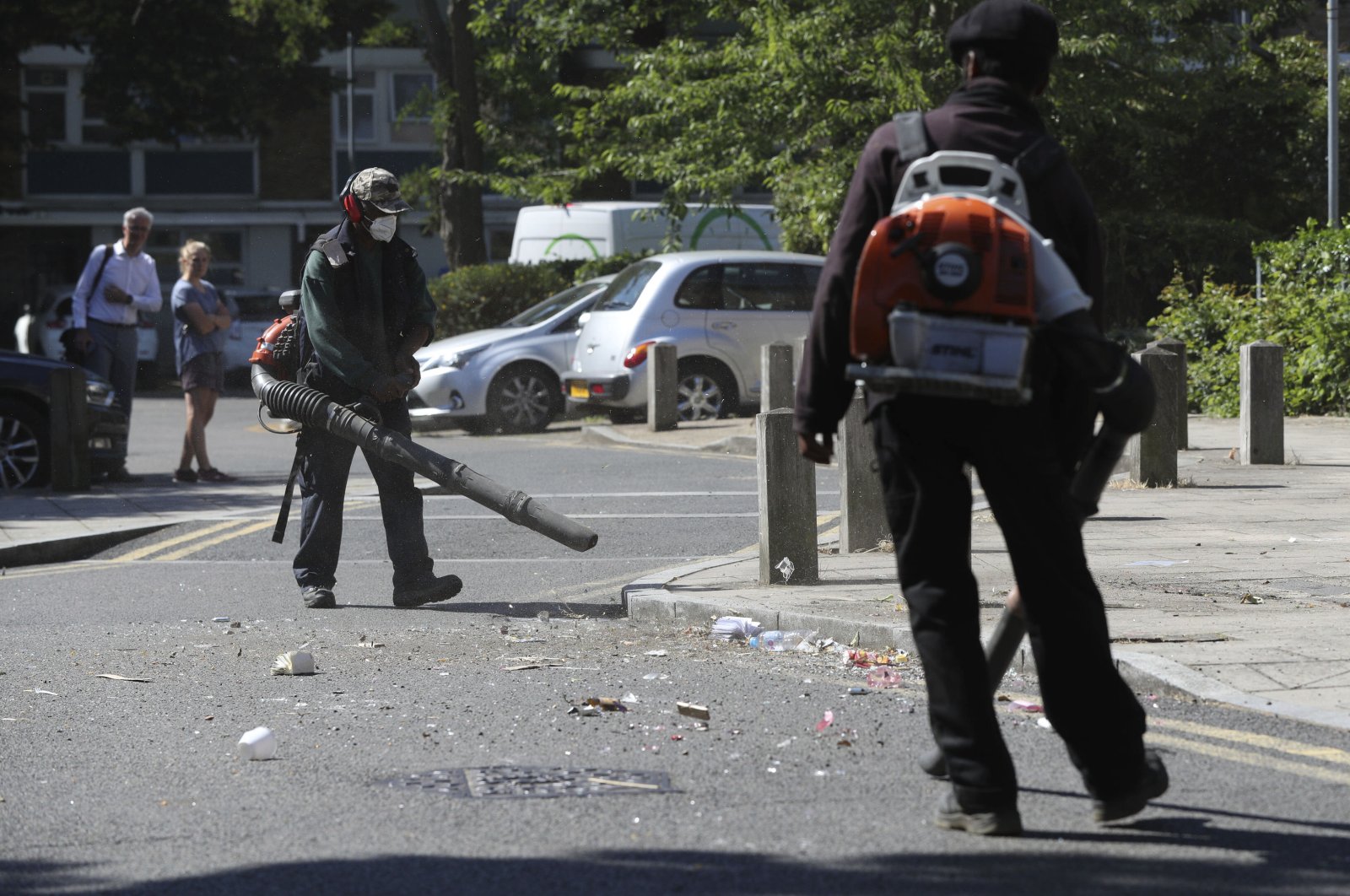 Volunteers clean up following violent confrontations with police that took place overnight in the Brixton area of London, June 25, 2020. (AP Photo)