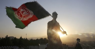 In this Aug. 19, 2019, file photo, a man waves an Afghan national flag during Independence Day celebrations in Kabul, Afghanistan. (AP Photo)