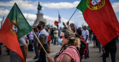 A protester wearing a face mask and a Portuguese flag takes part in a demonstration organised by the Portuguese far-right party Chega in Lisbon on June 27, 2020. (AFP Photo)