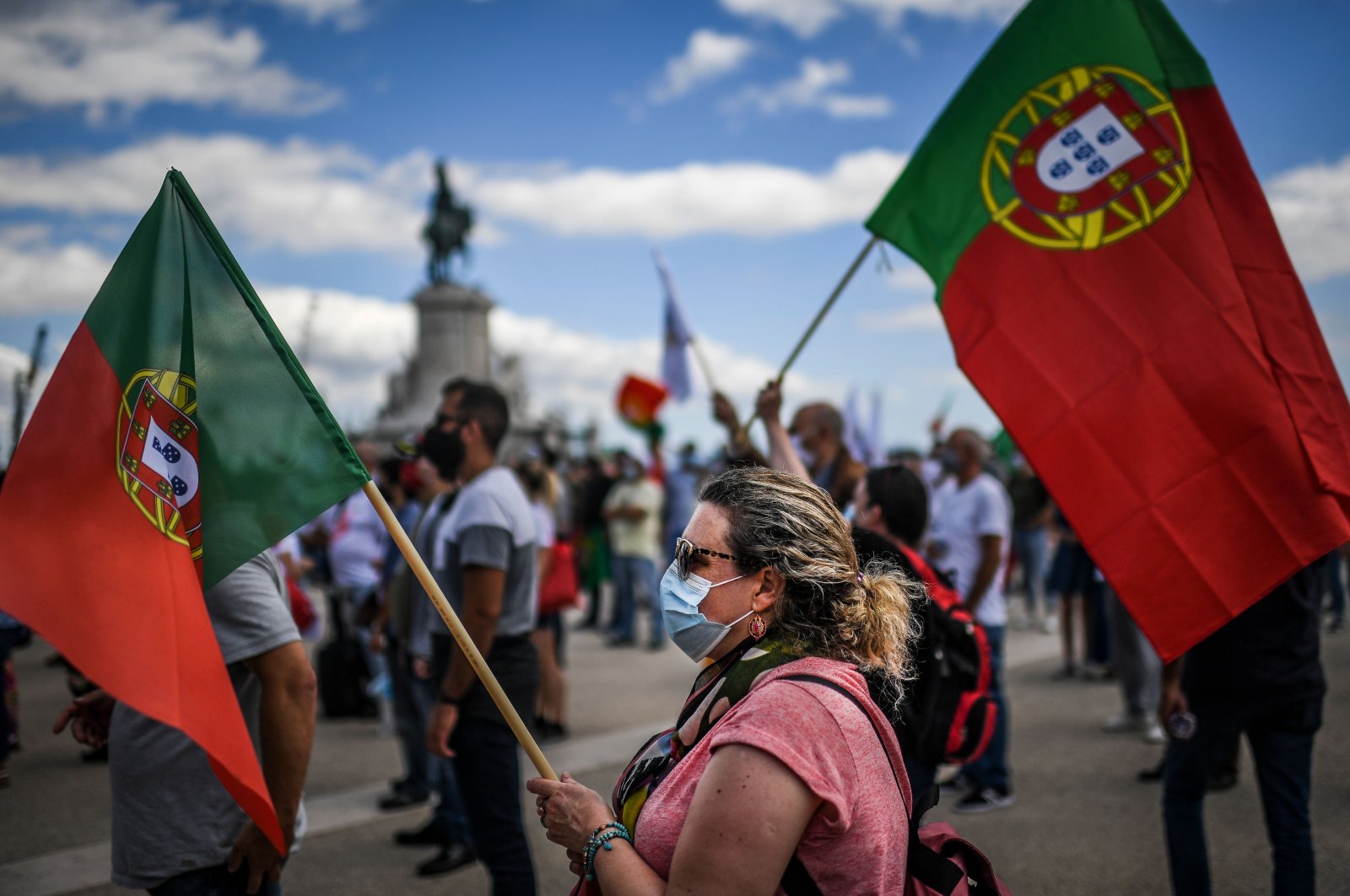 A protester wearing a face mask and a Portuguese flag takes part in a demonstration organised by the Portuguese far-right party Chega in Lisbon on June 27, 2020. (AFP Photo)