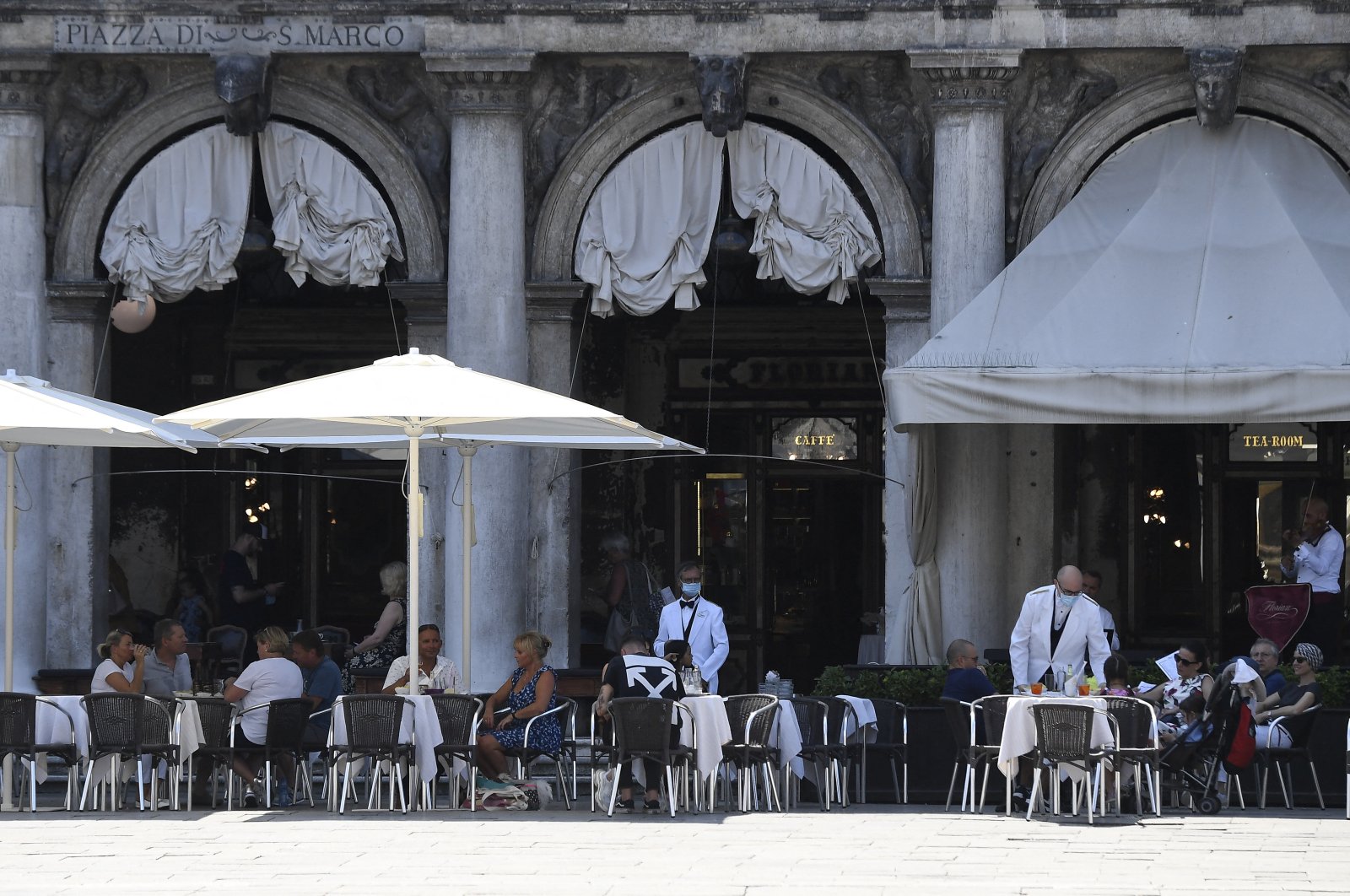 The first umbrellas were mounted that will cover the spaces in front of the premises, enlarged to facilitate the safe arrangement of the tables according to the safety rules on coronavirus, at San Marco square in Venice, Italy, on June 27, 2020. (Reuters Photo)