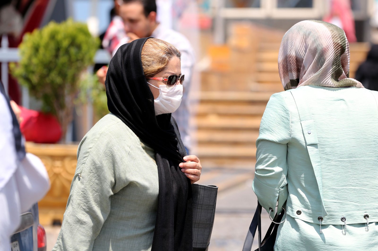 A pedestrian wearing a protective mask due to the coronavirus pandemic, walks along a street in the Iranian capital Tehran, June 28, 2020. (AFP Photo)