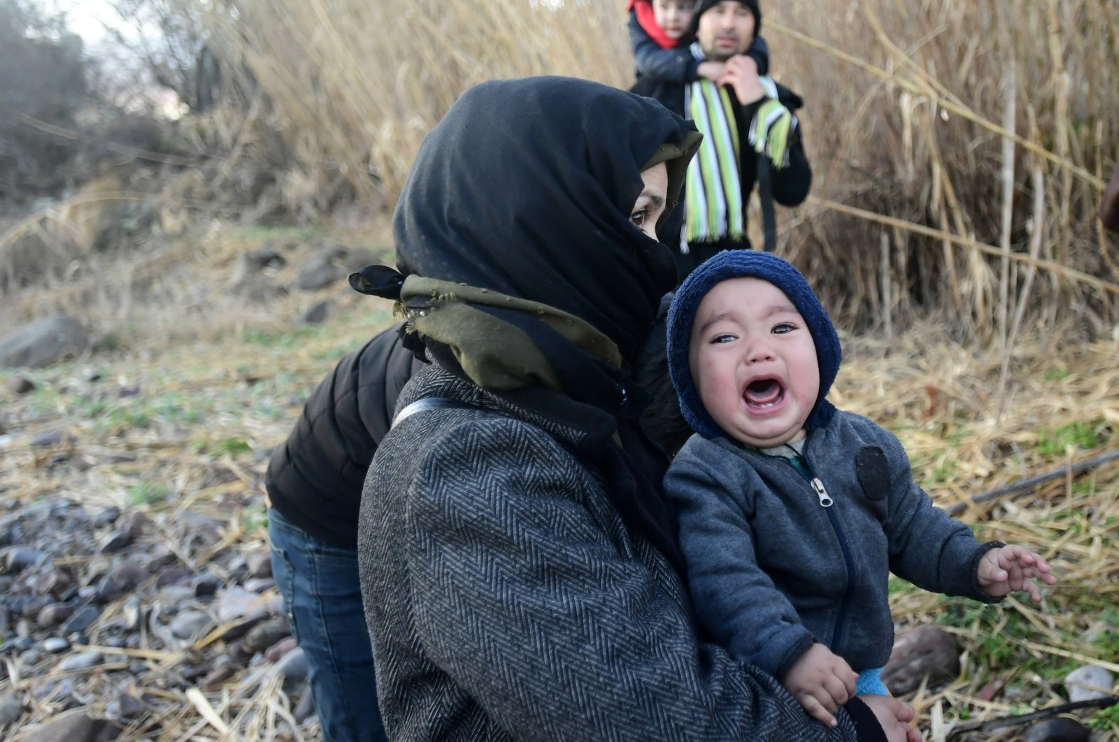 A baby cries as migrants arrive at the village of Skala Sikaminias, on the Greek island of Lesbos, after crossing on a dinghy the Aegean sea from Turkey, March 2, 2020. (AP Photo)