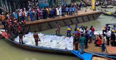Rescue workers bring the bodies of victims after a ferry capsized at the Sadarghat ferry terminal in Dhaka, June 29, 2020. (AFP Photo)