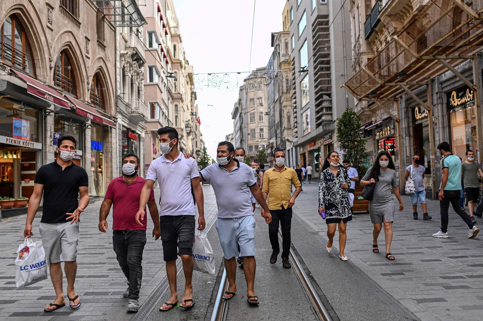 People wearing protective face masks to curb the spread of the coronavirus walk along the popular shopping hub, Istiklal Avenue, Istanbul, Turkey, June 25, 2020. (AFP Photo)