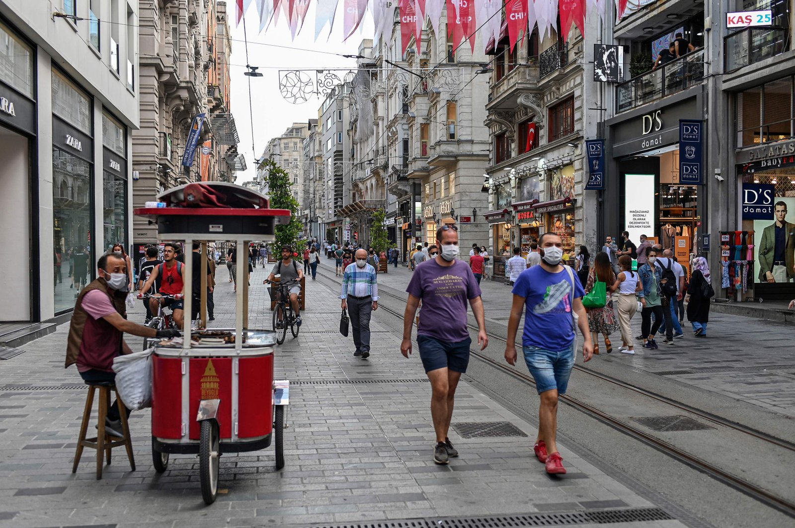 People wearing protective face masks to curb the coronavirus spread walk in popular shopping avenue Istiklal, Istanbul, June 25, 2020. (AFP Photo)