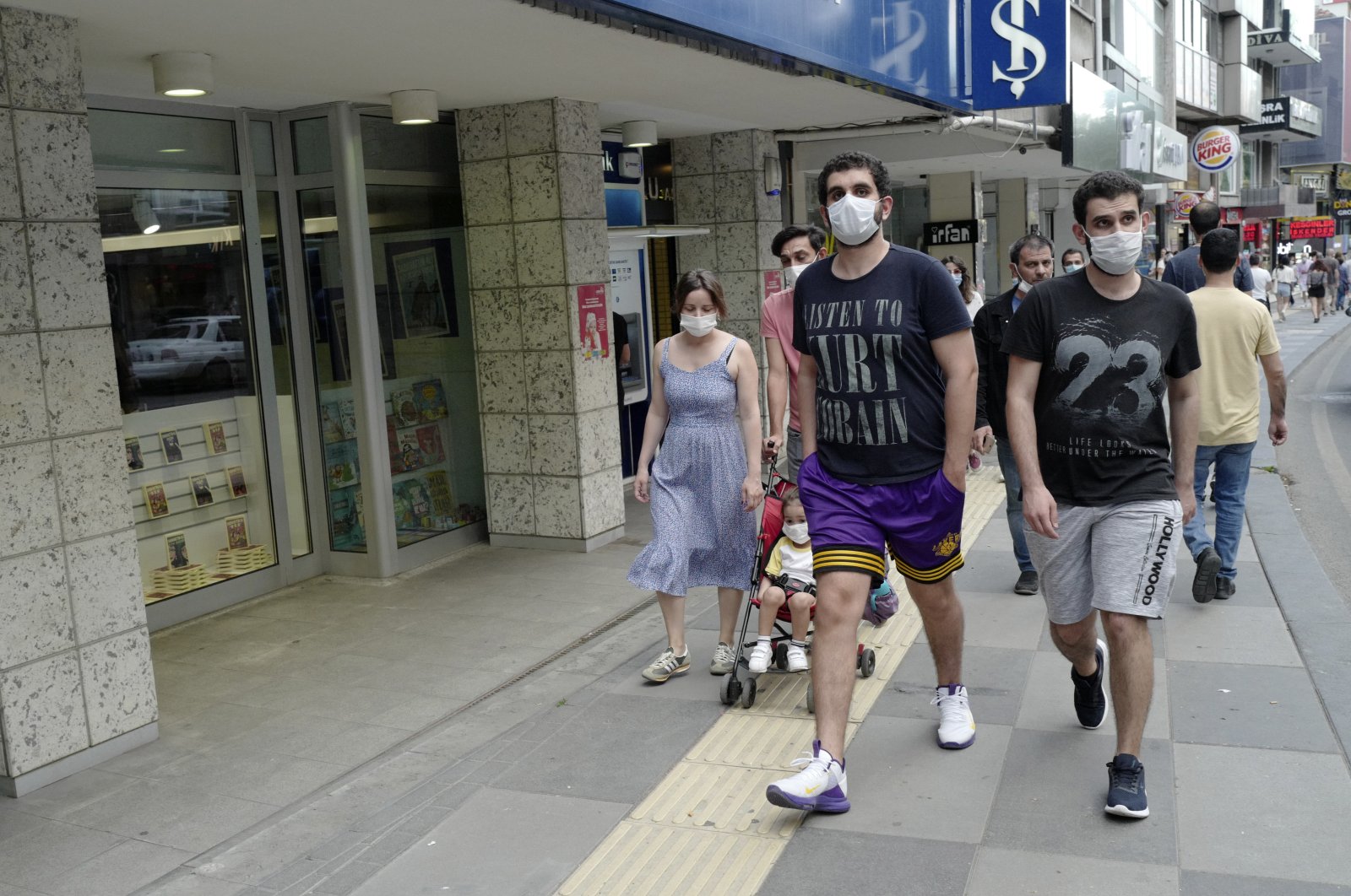 People wearing face masks to protect against the spread of coronavirus, walk in a popular shopping street after a nine-hour curfew, in Ankara, Turkey, June 28, 2020.