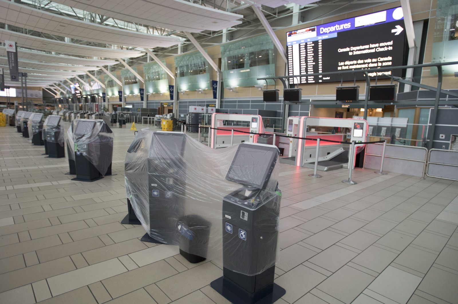 Check-in kiosks are covered in plastic at the domestic check-in, at Vancouver International Airport, Vancouver, Canada, June 9, 2020. (AP Photo)