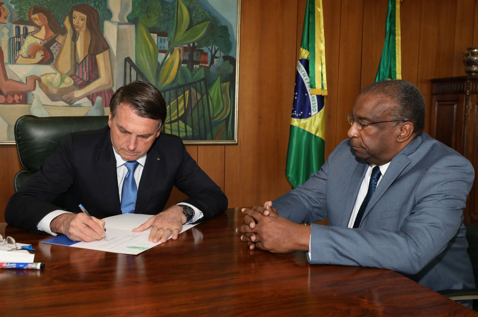 A handout photo released by the Brazilian Presidency press office shows President Jair Bolsonaro (L) and his new Minister of Education Carlos Alberto Decotelli, the first black minister in his Cabinet, at Planalto Palace in Brasilia, Brazil, June 26, 2020. (AFP Photo / Brazilian Presidency)