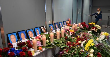 In this file photo, an employee walks in background of a makeshift memorial set up for the victims of the Ukraine International Airlines Boeing 737-800 that crashed near the Iranian capital Tehran, at the Boryspil airport outside Kiev, on January 11, 2020. (AFP Photo)