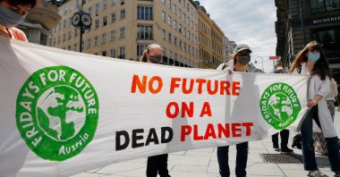People hold a banner during a protest march to call for action against climate change, as the spread of the coronavirus disease (COVID-19) continues, in Vienna, Austria, June 26, 2020.(Reuters Photo) 