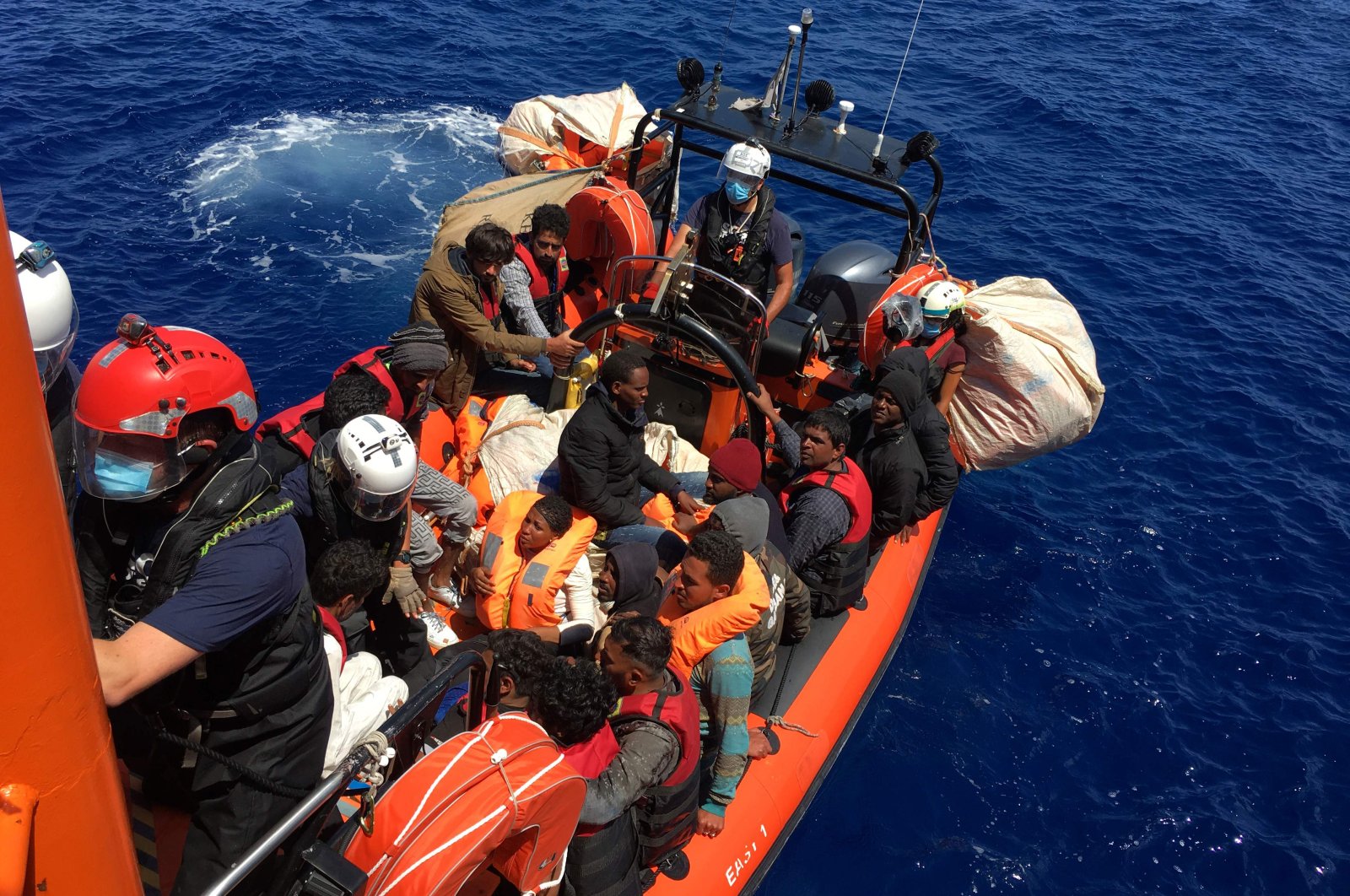 Some of the 51 migrants, who were drifting on a wood boat, are rescued by members of the French NGO SOS Mediterranee's boat Ocean Viking, off the coast of Lampedusa island, June 25, 2020. (AFP Photo)