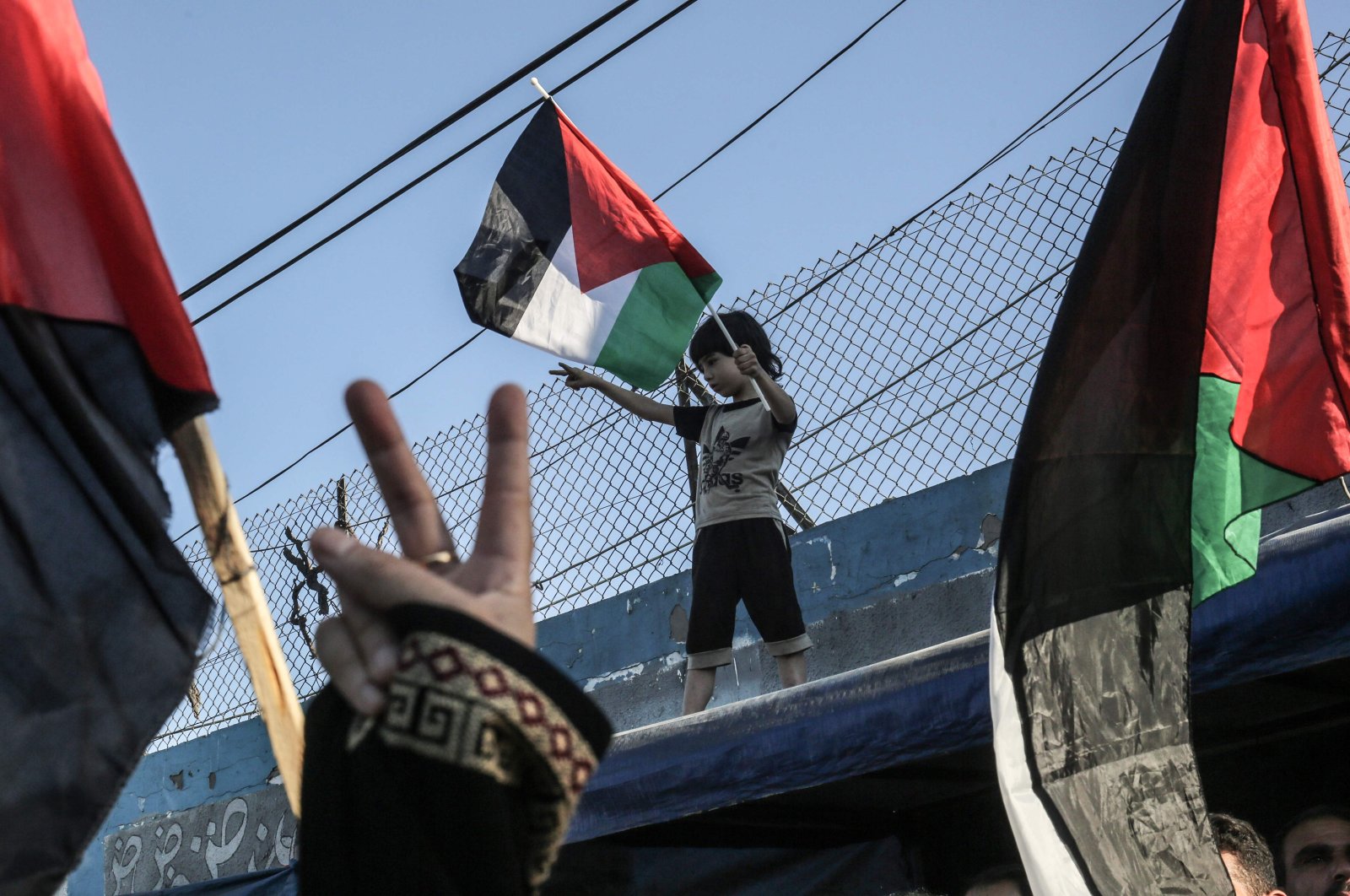 A Palestinian boy waves a national flag during a demonstration against Israel's West Bank annexation plans, in Khan Yunis in the southern Gaza Strip, July 2, 2020. (AFP)