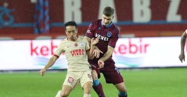 Galatasaray's Yuto Nagatomo (L) and Trabzonspor's Alexander Sorloth vie for the ball during a Süper Lig match in Trabzon, Turkey, Dec. 1, 2019. (AA Photo)