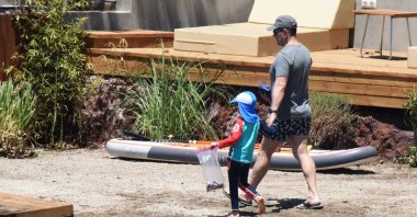 Alexander Svetakov walks in a beach near Bodrum with his son, July 3, 2020. (IHA Photo)