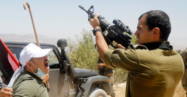 A Palestinian demonstrator reacts as an Israeli soldier fires a weapon during a protest against Israel's plan to annex parts of the occupied West Bank, Asira ash-Shamaliya near Nablus July 3, 2020. (Reuters Photo)