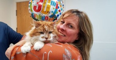 Rubble's owner Michele Heritage poses with her cat in his 30th birthday, June 4, 2020. (DHA Photo)