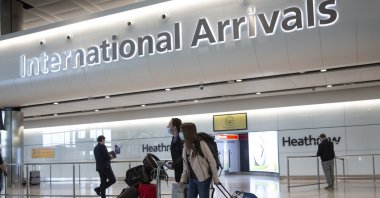 Passengers wearing face masks arrive at London's Heathrow Airport, June 8, 2020. (AP Photo) 