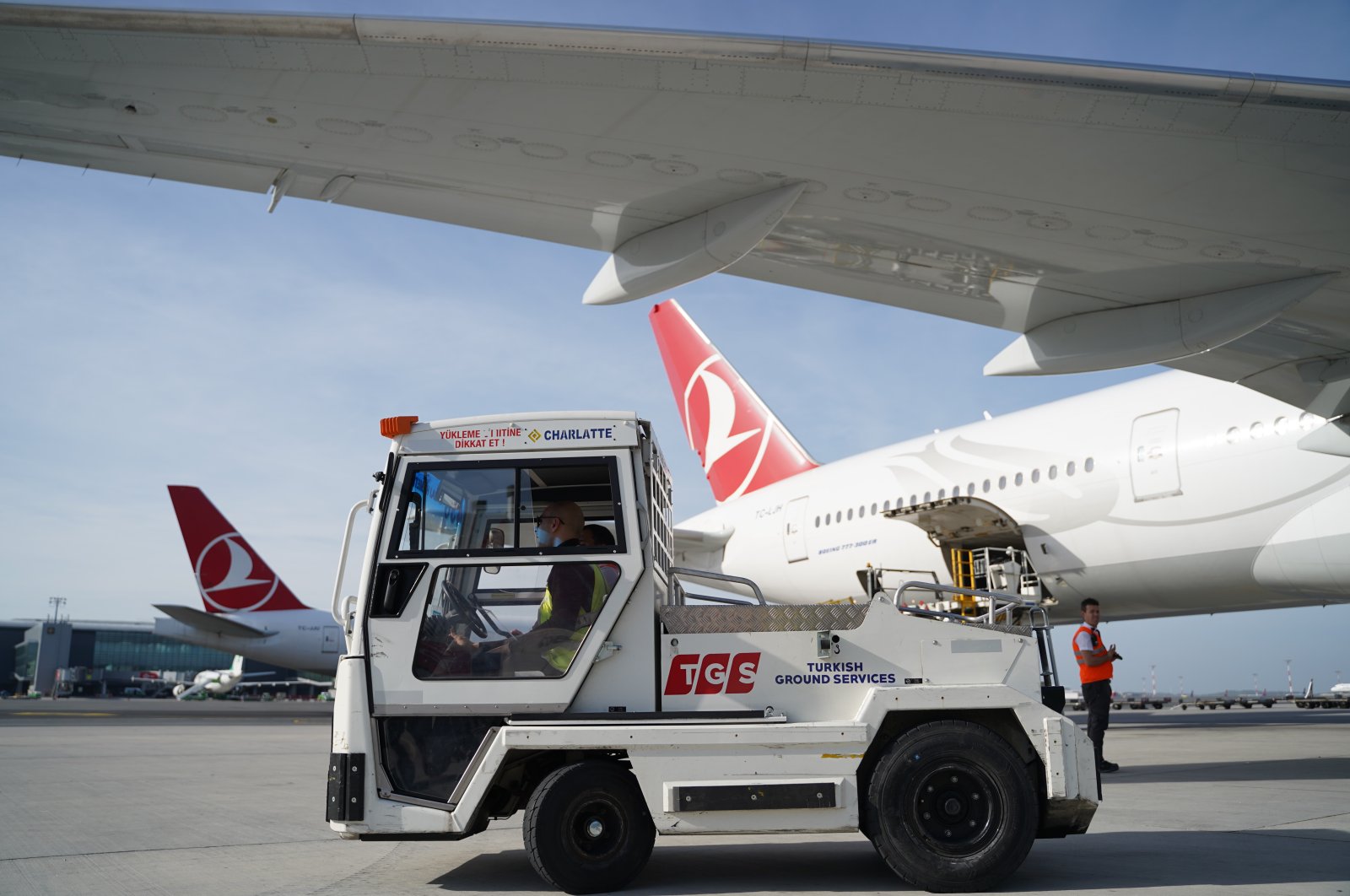 An electric vehicle used to transport luggage to airplanes approaches a THY plane in Istanbul, Turkey. (İHA Photo)