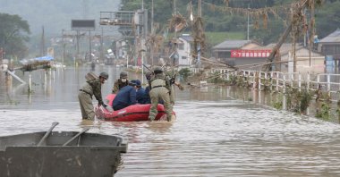 Japan Self-Defense Forces and police officers handle an inflatable boat to join rescue operations at a nursing home following heavy rain in Kuma village, Kumamoto prefecture, July 5, 2020. (AFP Photo)