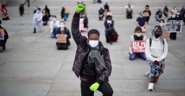 A protester makes a Black Lives Matter fist at a demonstration in Trafalgar Square in central London, to show solidarity with the Black Lives Matter movement in the wake of the killing of George Floyd, Britain, June 5, 2020. (AFP Photo)